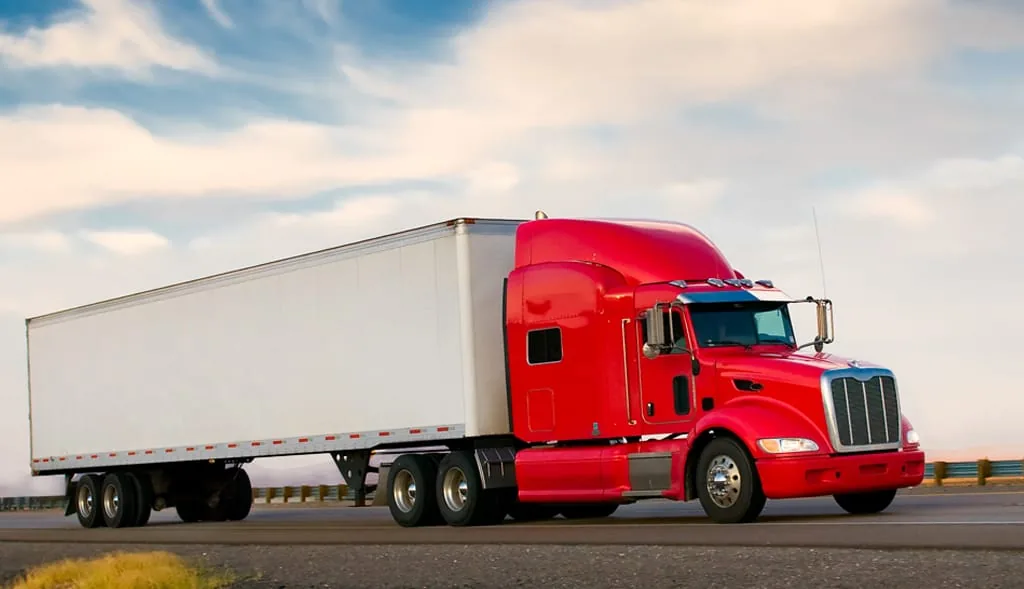 Commercial semi truck hauling a 53ft dry van trailer on an interstate highway